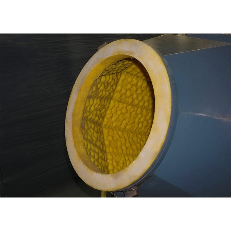 The image shows a close up of a metal object with a yellow filter on it, which appears to be a heat exchanger. The filter is made of metal and has a cylindrical shape with a handle on the side. The ye