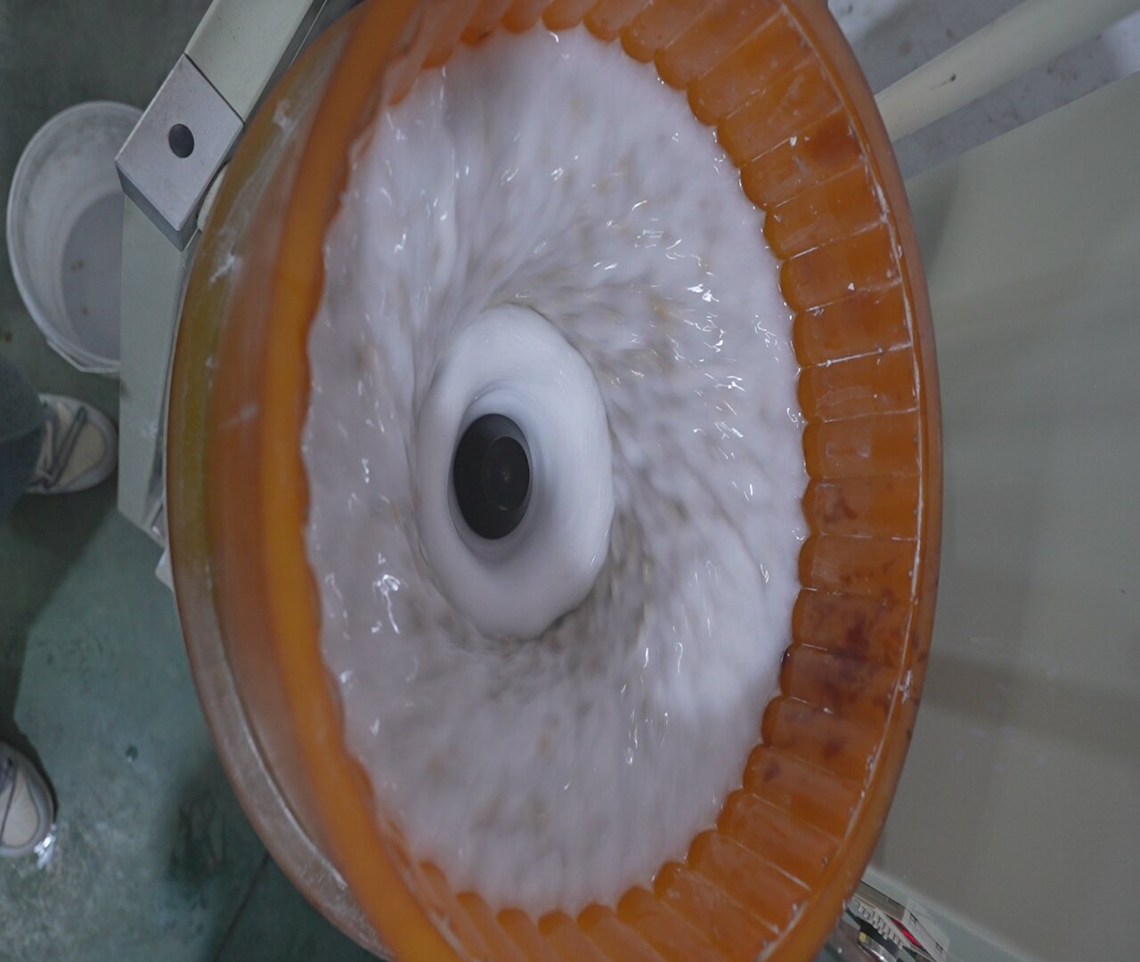 Interior de una máquina de cubeta durante un ciclo húmedo, que muestra el medio y el agua en movimiento